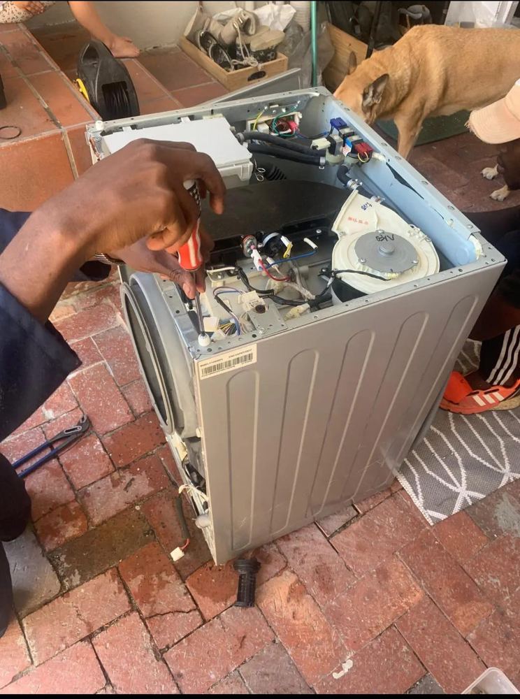 BIG6 technician repairing a washing machine on site