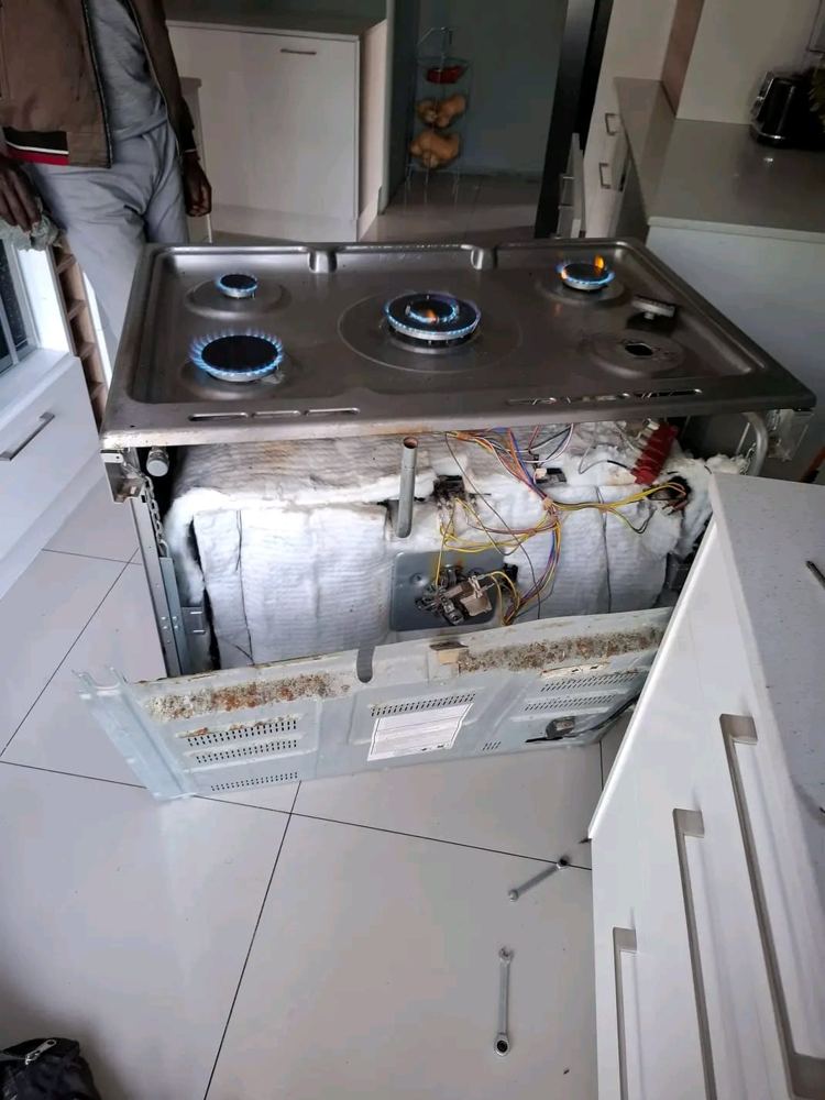 Gas stove opened up for repair with burners lit