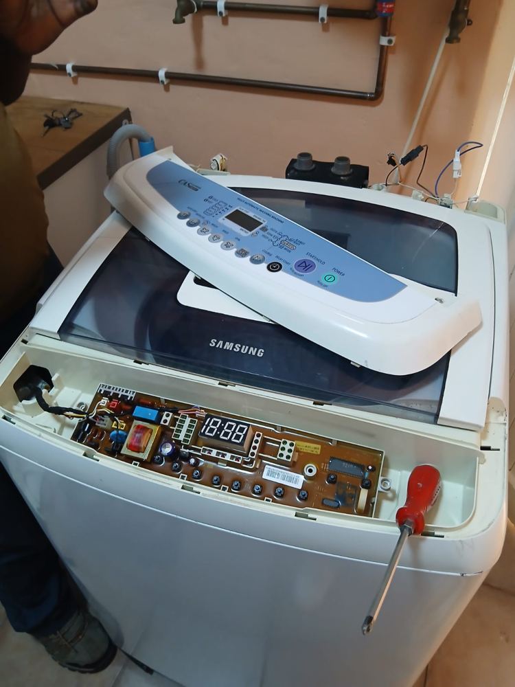 Samsung top loader washing machine with the control panel removed during a repair